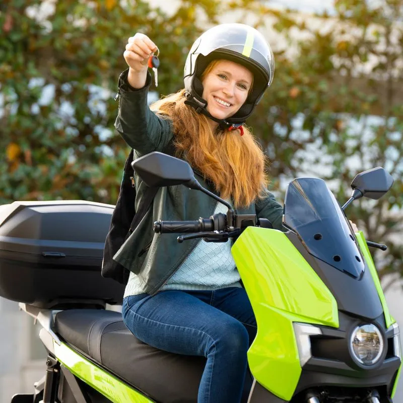 Picture of a happy woman with a new motorbike they purchased